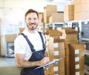 An immigrant worker sorting inventory listing in his job in Canada